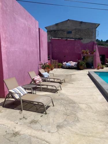 圣塔伦São Miguel House , Casa do Carvalhal的一组椅子坐在粉红色的墙上