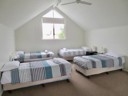 格纳拉巴普Ocean View Beach House, Margaret River的白色的客房设有四张床和窗户。