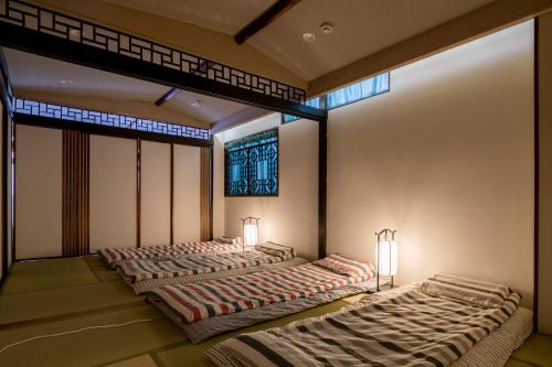 横滨Room Inn Shanghai 横浜中華街 Room3的带2扇窗户的客房内的2张床