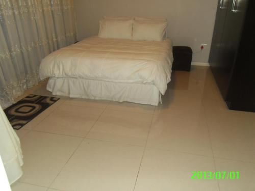 德班莉莉的避风港公寓的卧室配有1张床,铺有瓷砖地板。