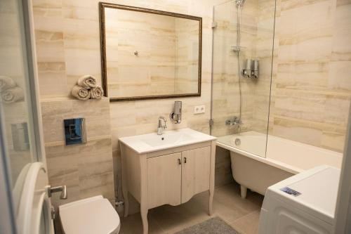 克莱佩达Old Town River Apartments的浴室配有盥洗盆、卫生间和浴缸。