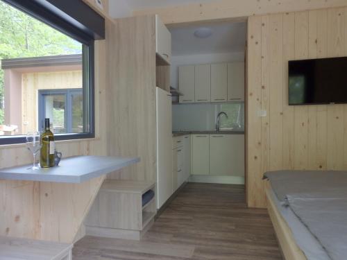 阿伊多夫什契纳Small holiday houses的一间带木墙和大窗户的厨房