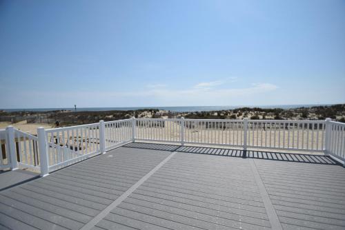 大洋城Ocean Club 4011 townhouse的一个带白色围栏和海滩的大甲板