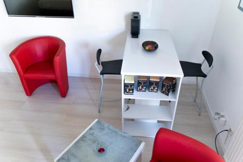 罗拉赫Ferienwohnung Dennis的一间设有白色桌子和红色椅子的客房