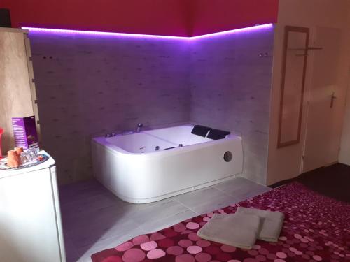 哈维若夫Penzion Vulture Havířov的浴室设有白色浴缸,拥有紫色墙壁