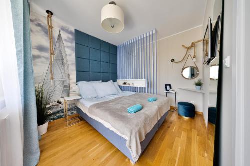 弗瓦迪斯瓦沃沃Klif Residence的一间卧室配有一张大床和蓝色床头板