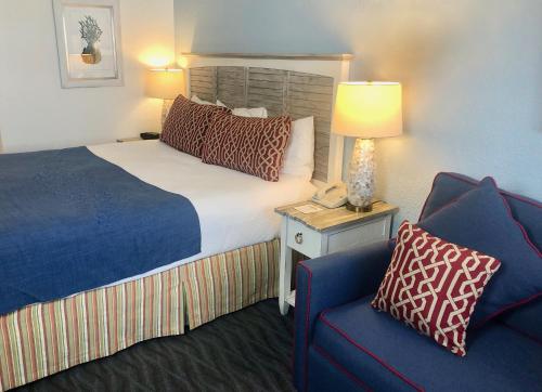 柏斯海滩Beach View Hotel的酒店客房,配有一张床和一张蓝色椅子