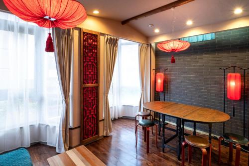 横滨Room Inn Shanghai 横浜中華街 Room3的一间带桌子和红色吊灯的用餐室