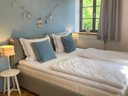 RadeburgLandgut Mosch的卧室配有带枕头的床铺和窗户。