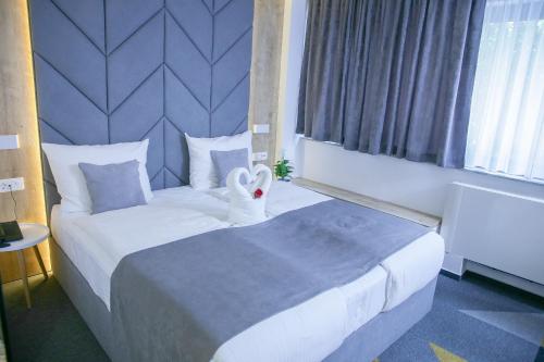 萨拉热窝Hotel Boutique Bristol的酒店客房,配有一张大床,并拥有天鹅装饰