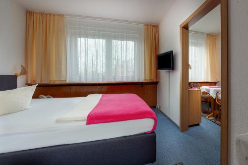 新勃兰登堡Hotel Horizont GmbH的酒店客房设有一张带红色毯子的大床
