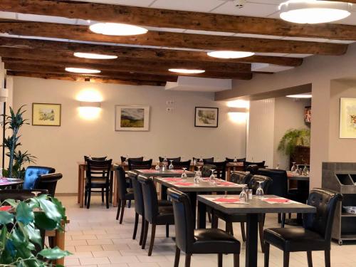 MontgreleixAuberge du Cezallier的餐厅用餐室配有桌椅