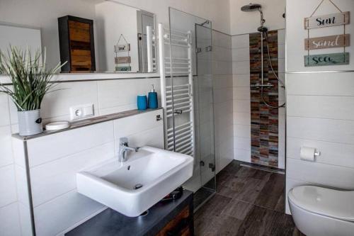 卢布明Ferienwohnung TinyBeach的白色的浴室设有水槽和卫生间。