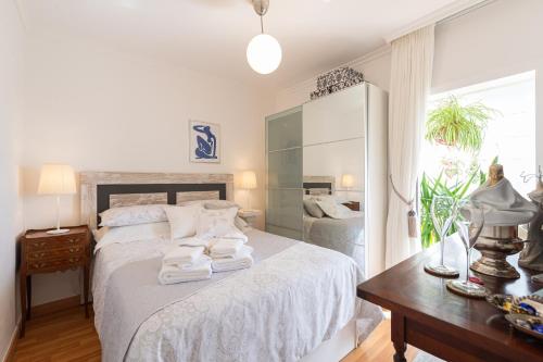 大加那利岛拉斯帕尔马斯Orchidea Home的白色卧室,配有带毛巾的床