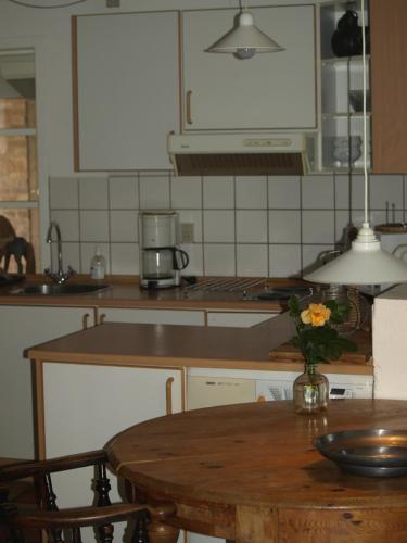HurupSkibstedgaard的厨房配有一张桌子,上面放着花瓶