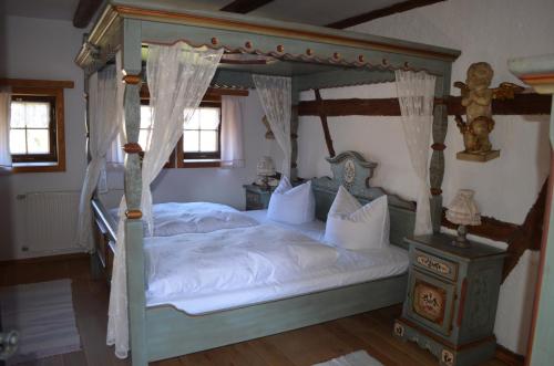 Burgstaedtzum Frongut的一间卧室配有一张带白色床单的四柱床
