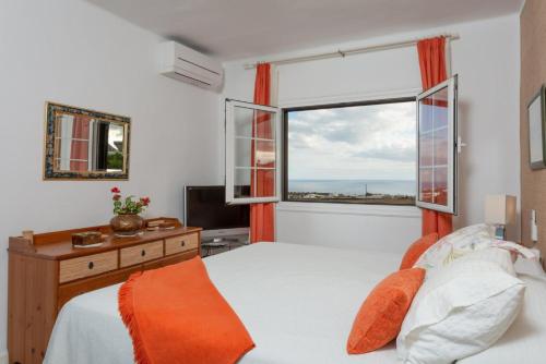 马赫安吉拉别墅的一间卧室设有一张床和一个大窗户