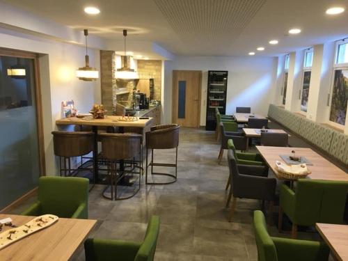 海利根布卢特拉格尔膳食公寓的餐厅设有木桌和绿色椅子