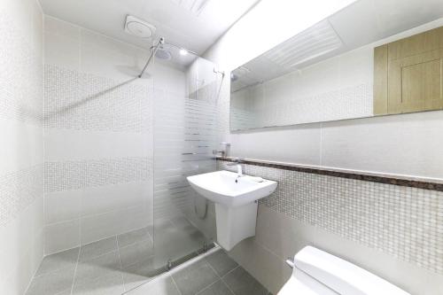 济州市Nohyung Hotel的白色的浴室设有水槽和卫生间。
