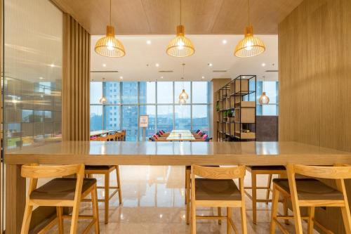 鞍山鞍山中心智选假日酒店的大型用餐室配有大型木桌和椅子