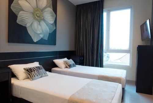 新加坡Hotel 81 Changi的酒店客房设有两张床和窗户。