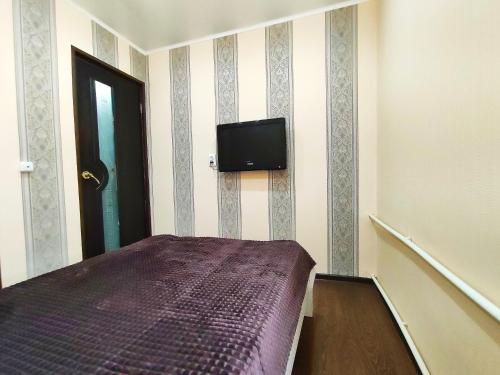 布古拉玛Апартаменты на Сайдашева 3的卧室配有一张床,墙上配有电视。
