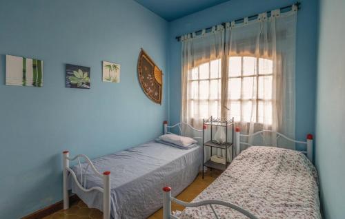 罗列特海岸Villa Suria的配有两张床铺的蓝色墙壁和窗户