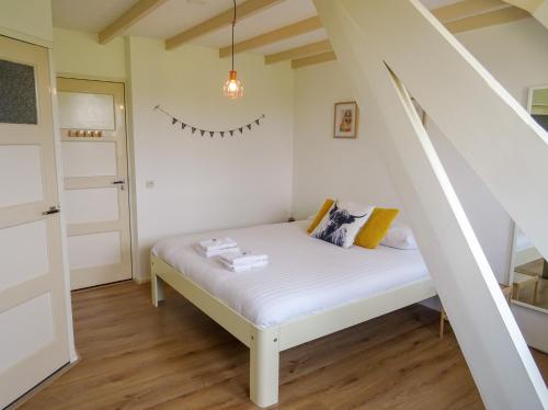 WinssenBed and Breakfast Maas en Waal的小房间设有白色的床和楼梯