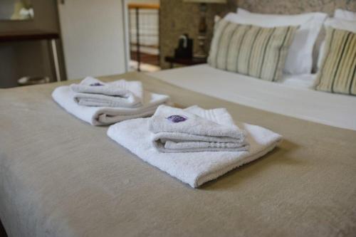 蓬戈拉Elegant Lodge & Conference Center的三条毛巾都放在床上