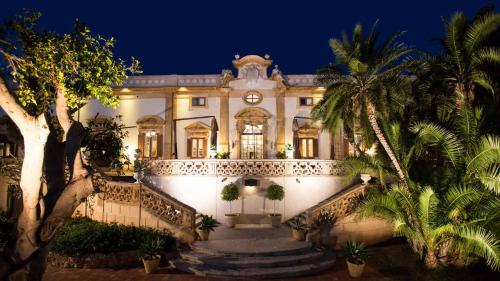 巴格里亚Holiday home La Rinascita的一座晚上有楼梯和棕榈树的建筑