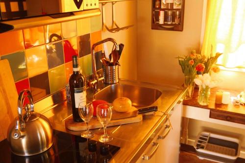 HoogmadenTulpenhuys的厨房柜台配有水槽和酒杯