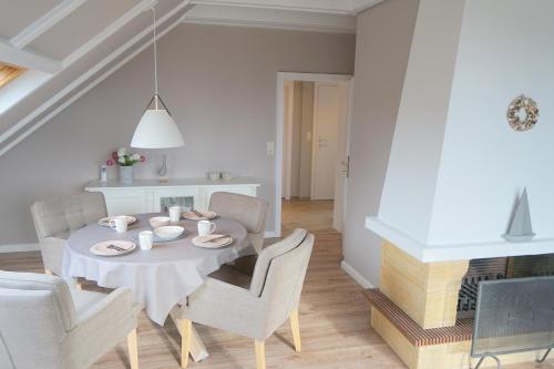 克伦胡森Haus Ruh di ut Wohnung LUV的白色的用餐室配有桌椅