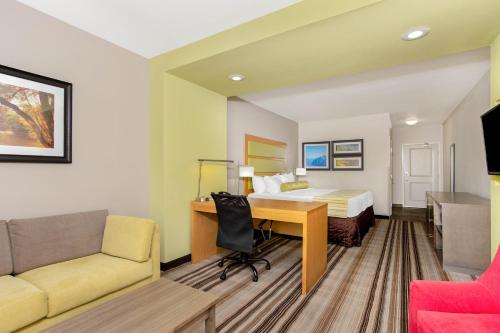 帕迪尤卡帕迪尤卡拉金塔旅馆及套房的配有一张床和一张书桌的酒店客房