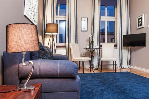 比得哥什格鲁瓦尔德兹齐公寓式民宿的客厅配有蓝色的沙发和桌子