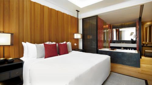 清迈Anantara Chiang Mai Serviced Suites的一间带白色大床的卧室和一间浴室