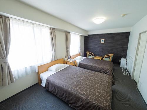 大阪Hotel Shin Osaka / Vacation STAY 81527的酒店客房设有两张床和窗户。