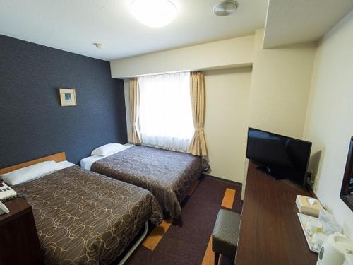 大阪Hotel Shin Osaka / Vacation STAY 81525的酒店客房设有两张床和一台平面电视。