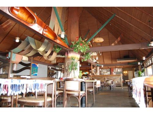 奄美Amami Resort Bashayamamura / Vacation STAY 81475的餐厅设有桌椅和天花板上的冲浪板