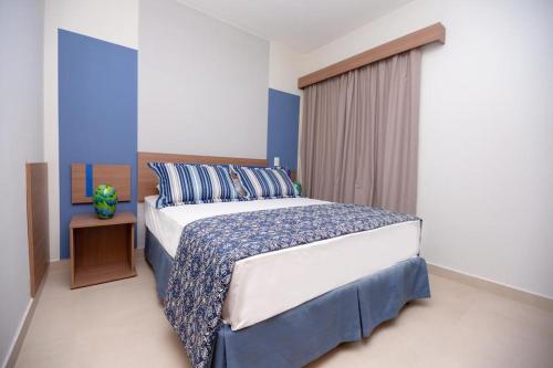 卡达斯诺瓦斯Alta Vista Thermas Resort的一间卧室配有一张特大号床和蓝色的墙壁