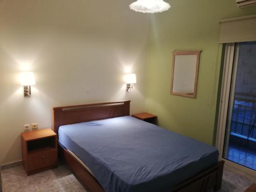 沃拉哈蒂Rea's House Vrachati的卧室配有一张床,墙上有两盏灯