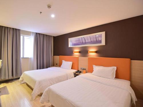 Laizhou7天优品·莱州市政府店的一间酒店客房,房间内设有两张床