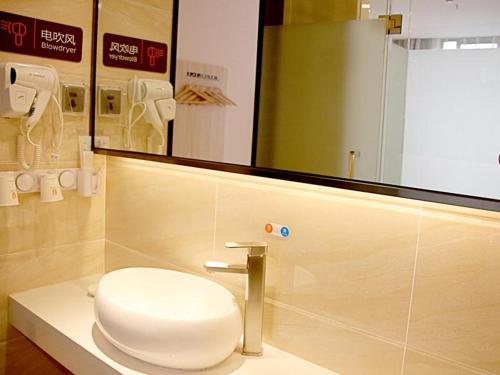 重庆7天优品重庆南坪步行街轻轨站店的浴室设有卫生间和镜子的台面