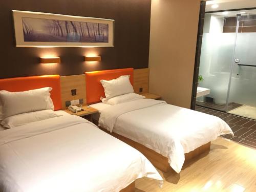安阳7天优品·安阳汤阴岳飞庙景区店的酒店客房,设有两张床和镜子