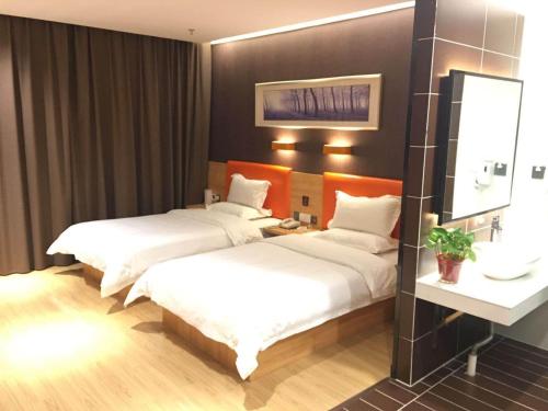 安阳7天优品·安阳汤阴岳飞庙景区店的酒店客房,设有两张床和镜子