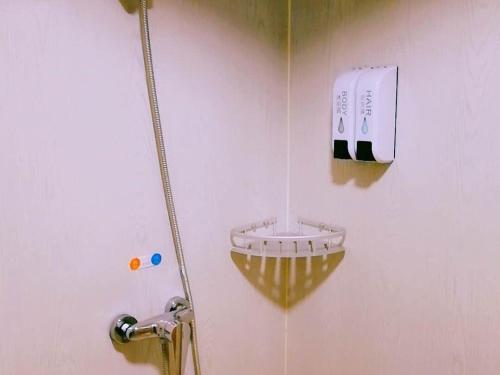 十堰7天优品十堰人民路三堰客运站店的墙上的浴室设有肥皂机