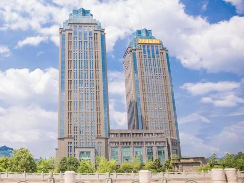 南川7天优品·重庆南川政府广场店的天空云 ⁇ 的城市里两座高耸的摩天大楼