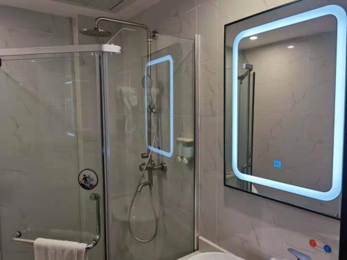 广州7天优品·广州广园客运站店的一个带玻璃淋浴间的浴室,位于后门