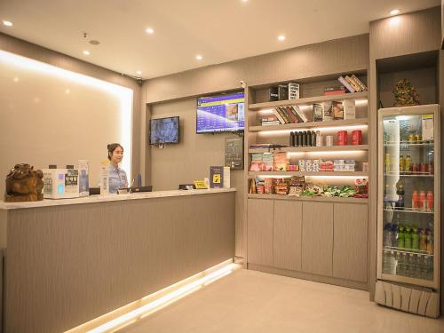 深圳7天优品·深圳竹子林地铁站店的站在商店柜台的女人