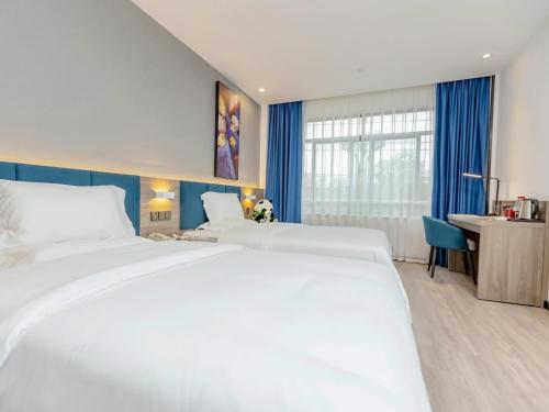 宜宾7天优品宜宾北门汽车站店的酒店客房配有两张床和一张书桌