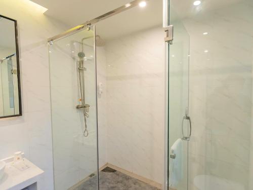 宜宾7天优品宜宾北门汽车站店的浴室里设有玻璃门淋浴